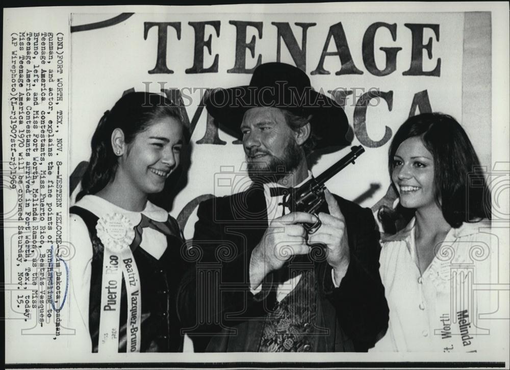 1969 Press Photo Jim Dakota actor explains gun handling to Teen America - Historic Images