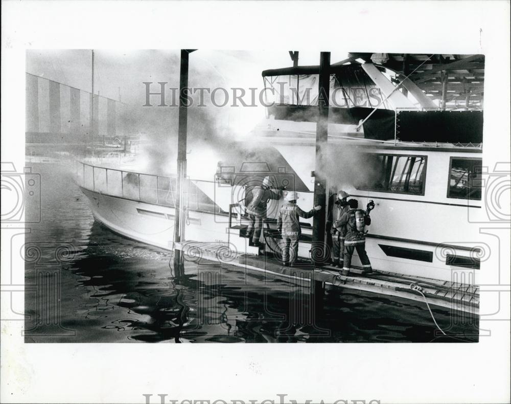 1988 Press Photo Firefighter work to put out blazing yacht in St Pete, Florida - Historic Images