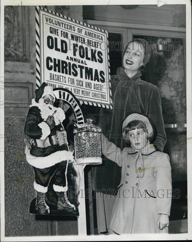 1951 Press Photo Genevieve Carisoles makes contribution, while Juli Dane looks - Historic Images