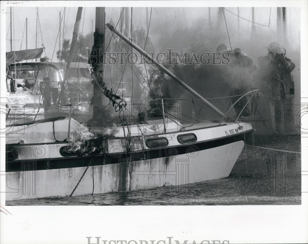 1986 Press Photo Firefighter work to put out blazing yacht in St Pete, Florida - Historic Images