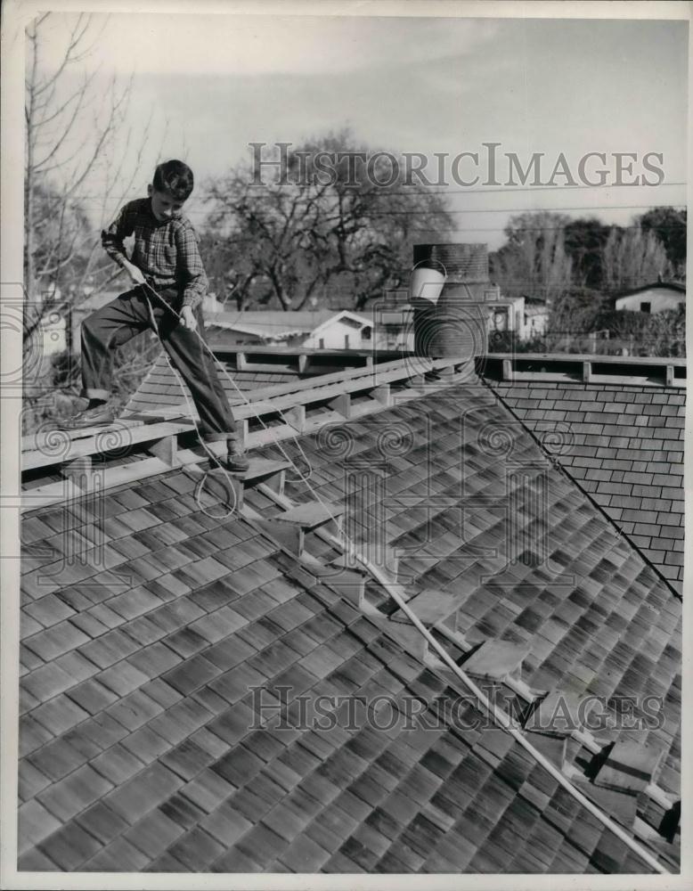 1942 Press Photo Drew Terramorse on roof of his home with fire hose - nea23882 - Historic Images