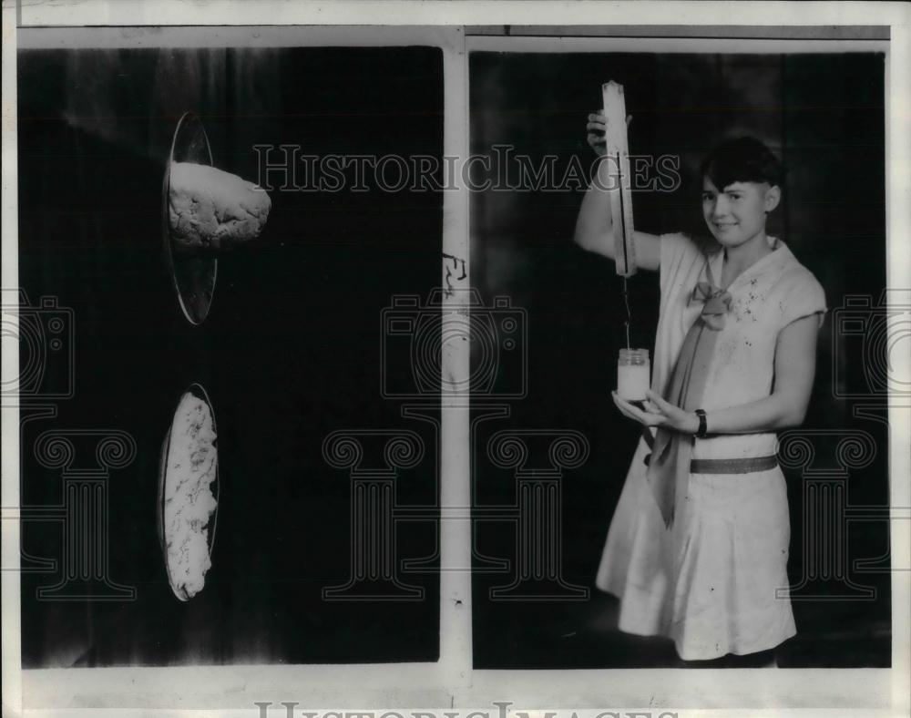 1930 Press Photo girl holding spring balanced knife in jar of curded milk - Historic Images