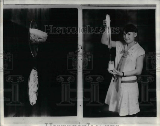 1930 Press Photo girl holding spring balanced knife in jar of curded milk - Historic Images