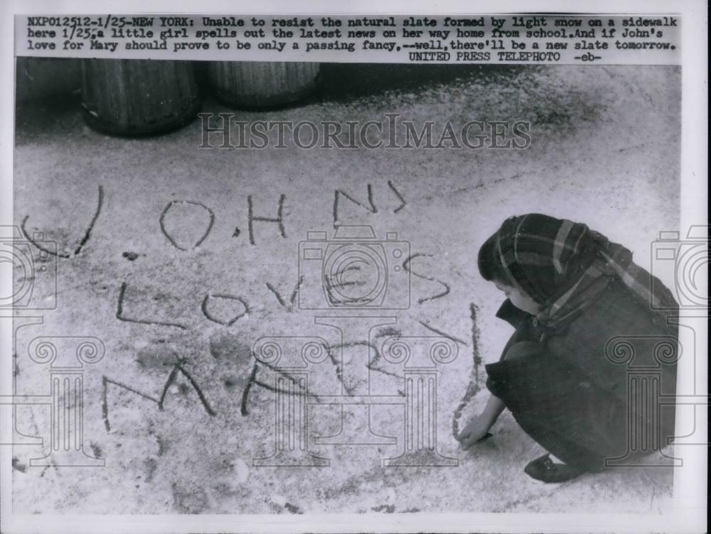 1957 Press Photo Little girl writing a note on the snow &quot;John Loves Mary&quot; - Historic Images