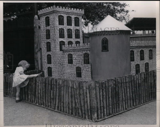 1949 Press Photo Kathy climbs over to get a better look inside the Guinea Pig - Historic Images
