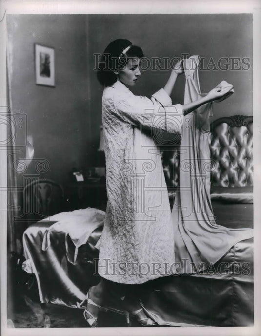 1956 Press Photo A Woman Holds And Looks At Lingerie - nea29605 - Historic Images