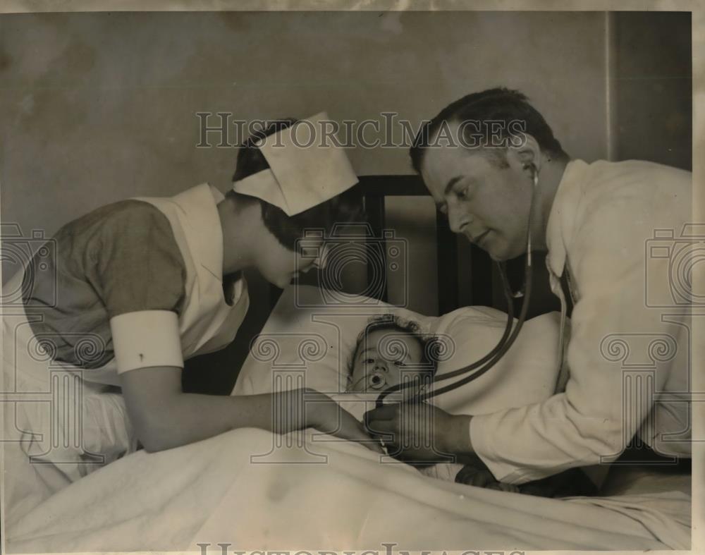 Press Photo Dr. AJ Krlich of Chicago helps with a baby in the hospital, Justin - Historic Images