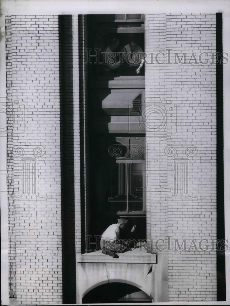 1955 Press Photo Harvey Harding sit on the edge of a Bldg. preparing to Jump. - Historic Images