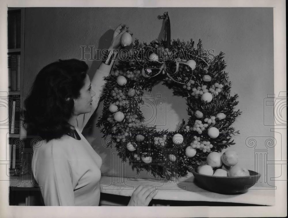 1948 Press Photo Woman Hangs Christmas Wreath In Her Living Room - nea31918 - Historic Images