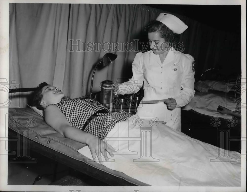 1953 Press Photo Miss Evelyn B.. Dinda giving blood Nurse Mrs. Josephine Aron - Historic Images