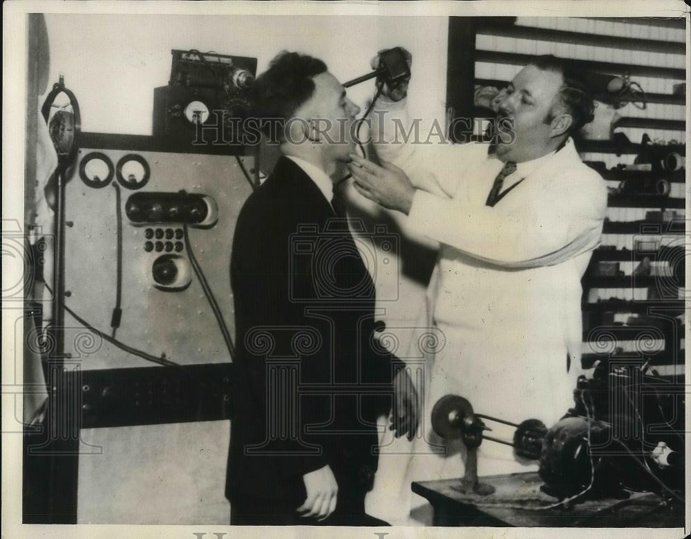 1931 Press Photo Dr.G.Russell making Sonometer test in Wallace Calhoun. - Historic Images