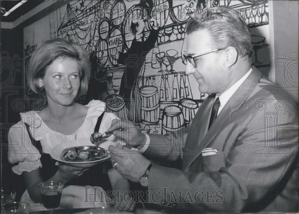 1965 Press Photo Man Shows Woman How To Eat Wienberqschnecken Dusseldorf Germany - Historic Images