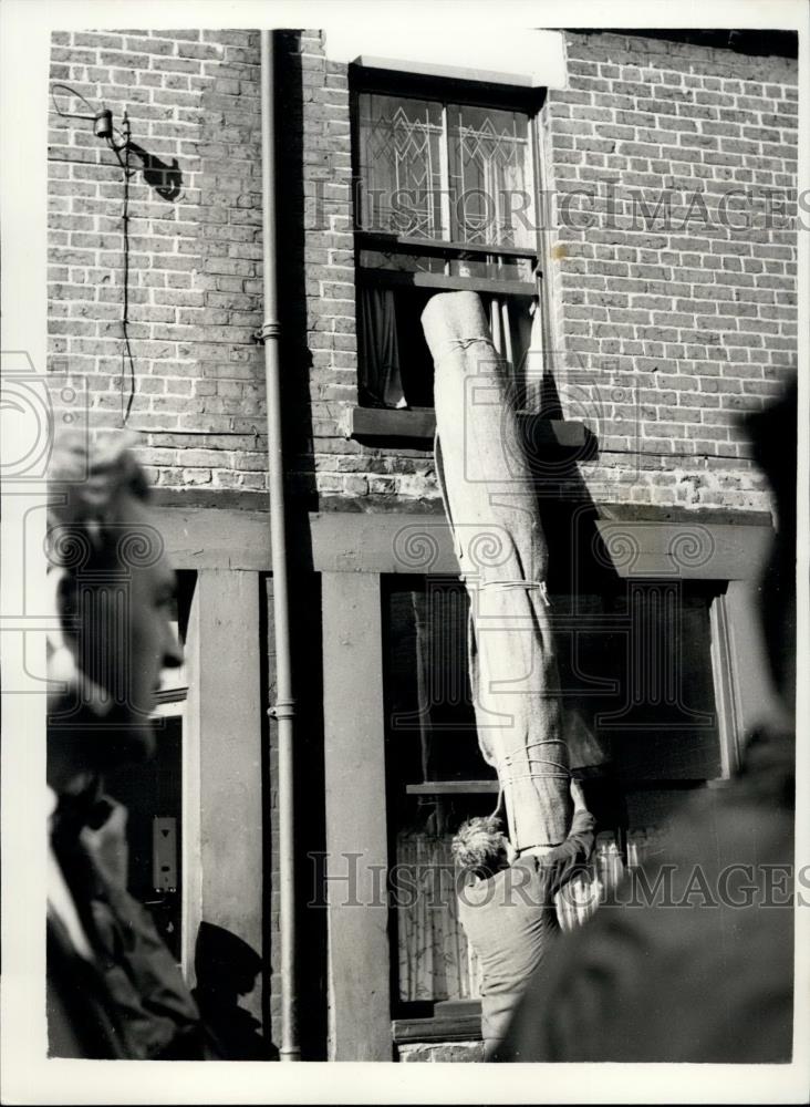 Press Photo Carpet Being Removed From A Home Stuck In Sinkhole - Historic Images