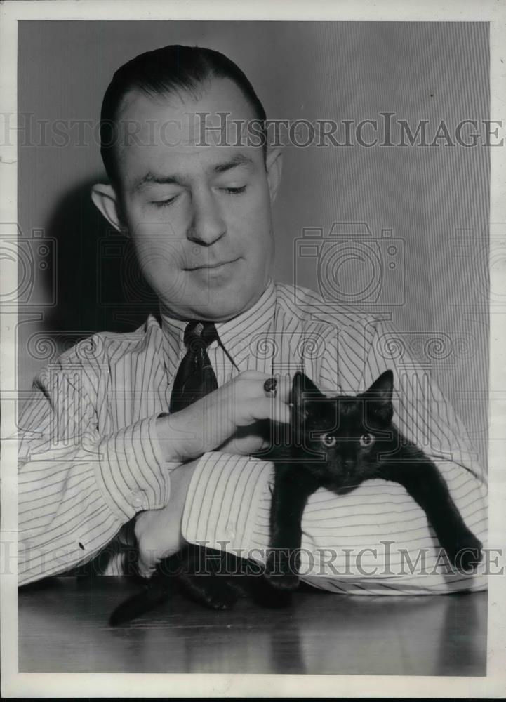 1941 Press Photo Murray Martin Credit manager on the 13th with black cat - Historic Images