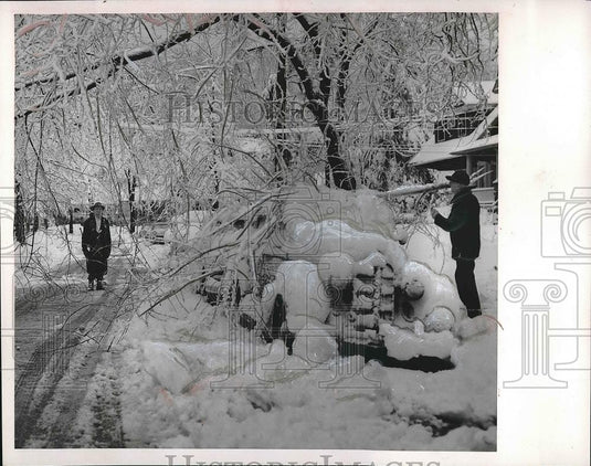 1954 Press Photo Man standing next to car frozen in ice - Historic Images