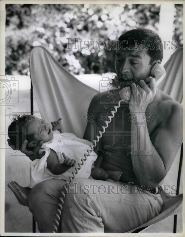 1960 Press Photo Dad Talking on Phone While Holding Baby - nea67129 - Historic Images