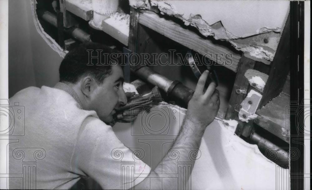 1957 Press Photo Mike Salafia tears holes in walls of home to find trapped cat - Historic Images