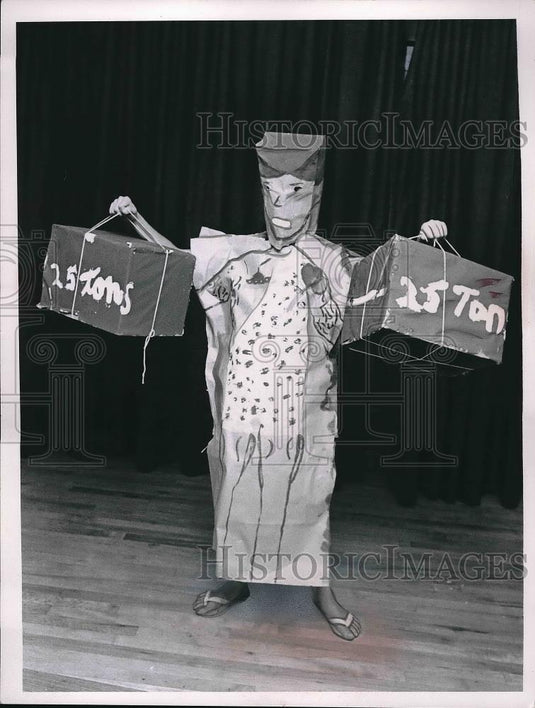1961 Press Photo Character holding 2 prop boxes indicating 15 & 25 tons for play - Historic Images