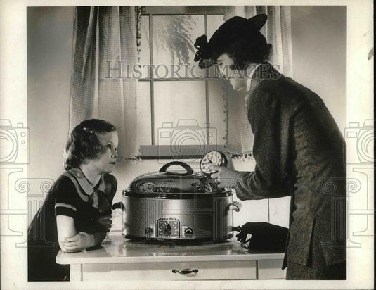 1936 Press Photo A housewife & daughter check a pressure cooker - Historic Images
