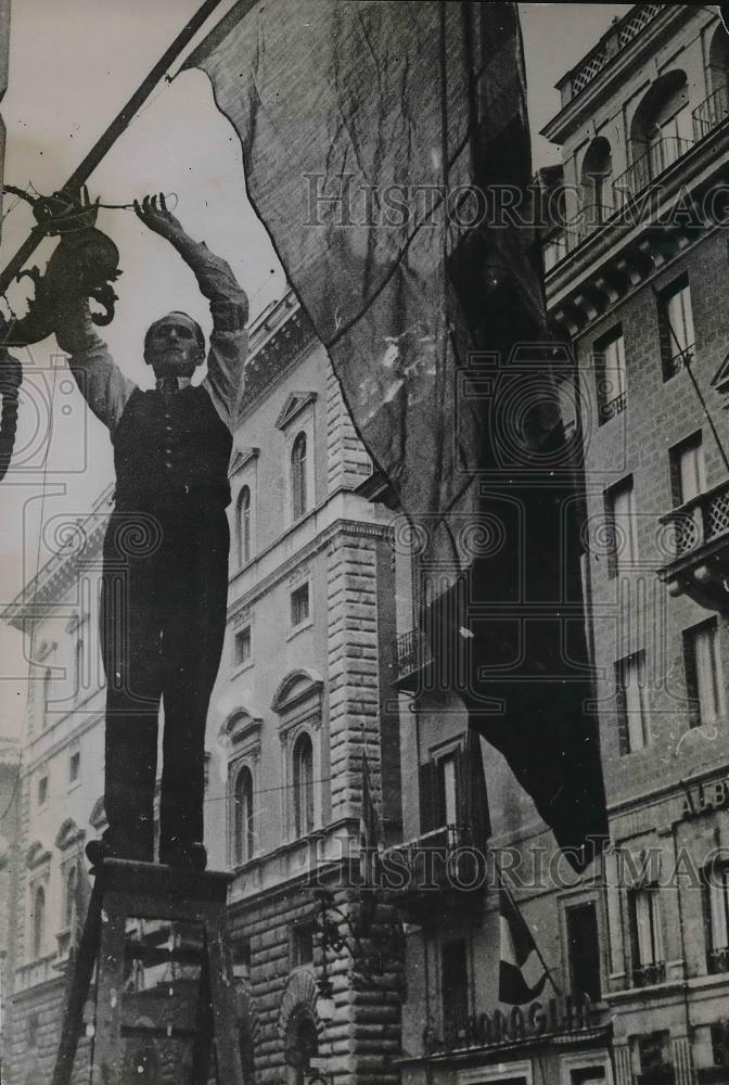 1935 Press Photo Italian protestor hanging &quot;Anti-Sanotions&quot; flag in Rome - Historic Images