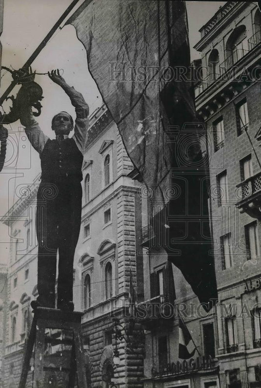 1935 Press Photo Italian protestor hanging "Anti-Sanotions" flag in Rome - Historic Images