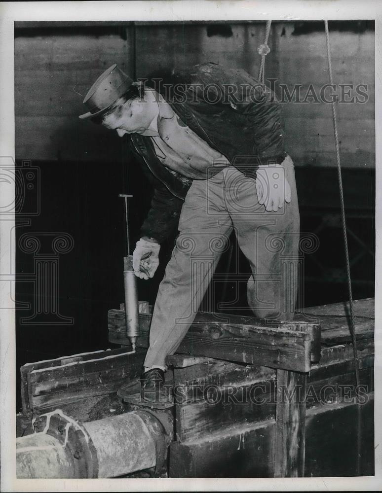 1957 Press Photo Ray DeYoung spreads chemical to ward off pigeons in Chicago - Historic Images