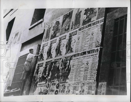 1946 Press Photo Worker tearing down Republican placards - Historic Images