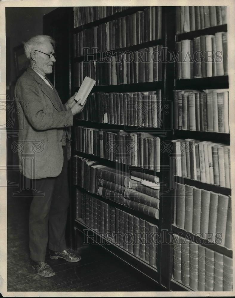 1928 Press Photo Jno Dunn, ex-convict, looking over books in the library - Historic Images