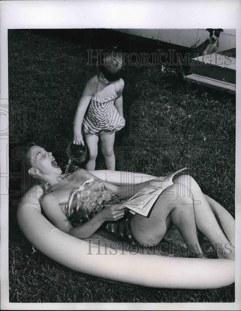 1957 Press Photo Three Year Old Renee Kissee Pours Water Over Mother - neb21425 - Historic Images