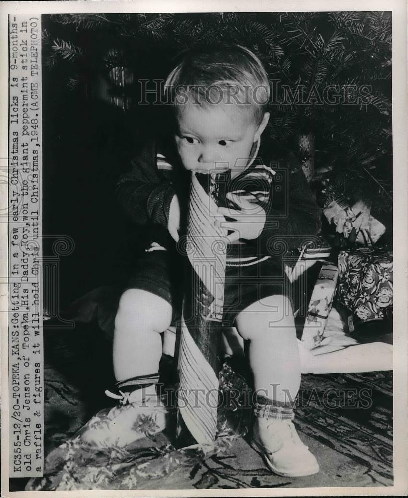 1947 Press Photo baby Chris Jenson sucking on giant candy cane at Christmas - Historic Images