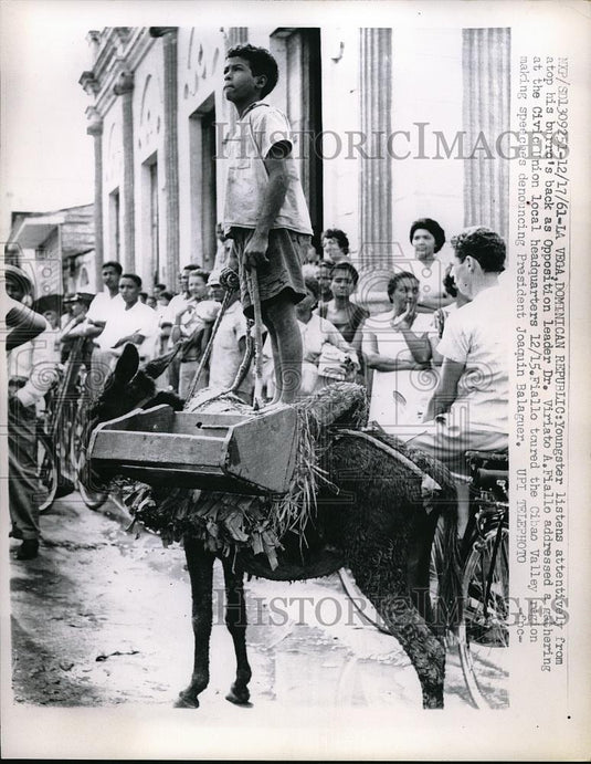 1961 Press Photo Youngster Listens From Burro to Dr. Viriato A. Fiallo, La Vega - Historic Images