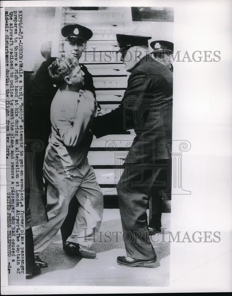 1954 Press Photo &quot;Bobby&quot; Has Arm Lock on Passenger at London Airport - Historic Images