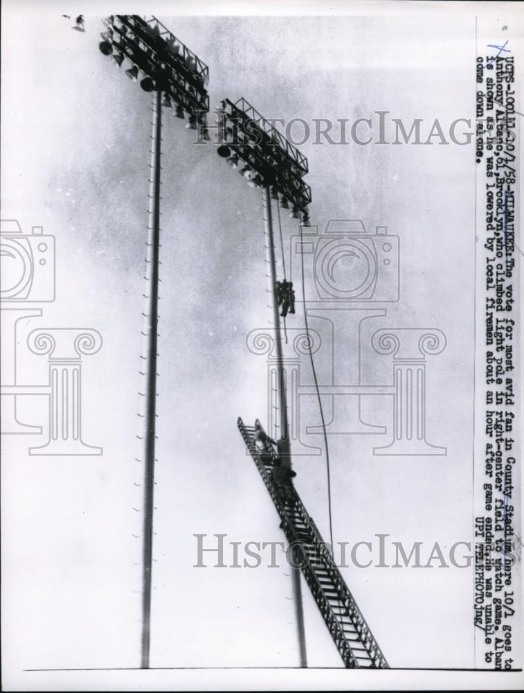 1958 Press Photo Anthony Albano Climbing Light Pole To Watch Milwaukee Game - Historic Images