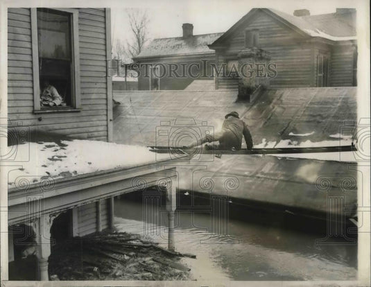 Press Photo Man trying a house-to-house ladder system to thwart the isolator of - Historic Images