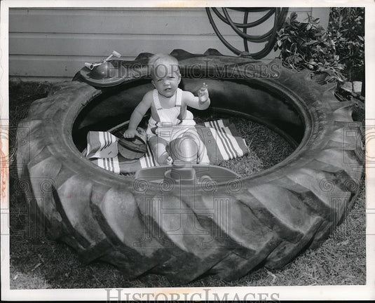 1959 Press Photo Scotty McDonald playing w/ a large tire - Historic Images