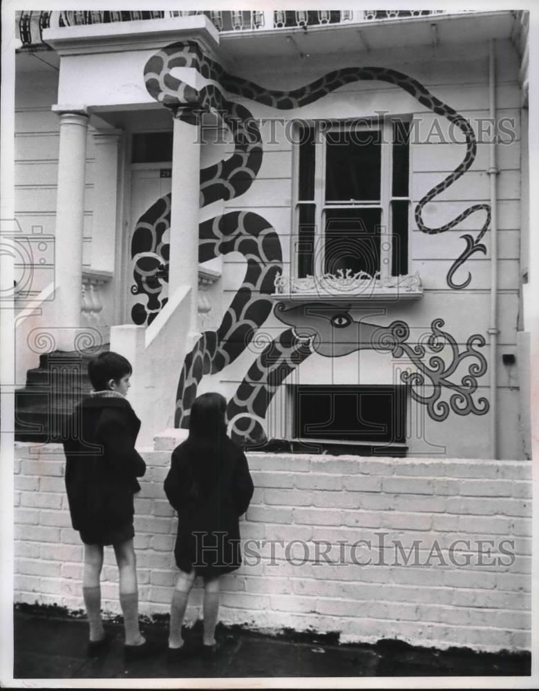 1967 Press Photo London, England, two children look at art on side of a house - Historic Images