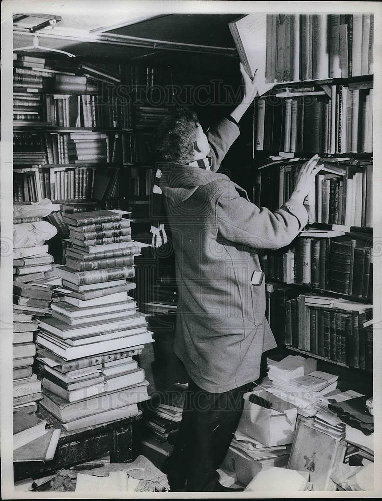 1961 Press Photo An unidentified person looking at books - Historic Images