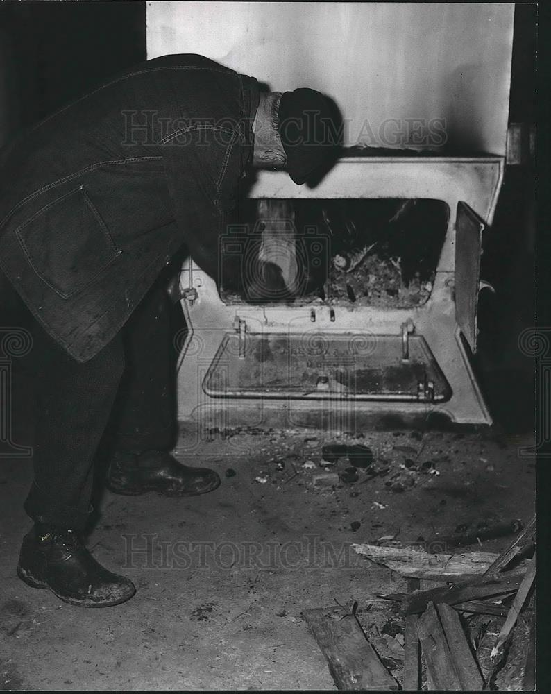 Press Photo C.W Thayer fires up a cooker with wood. - Historic Images