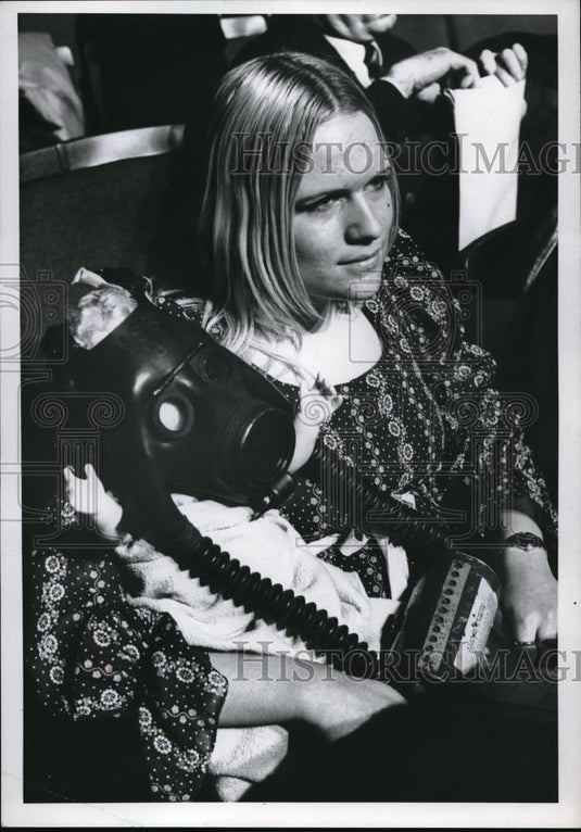 1970 Press Photo Woman Puts Gas Mask On Her Child - Historic Images