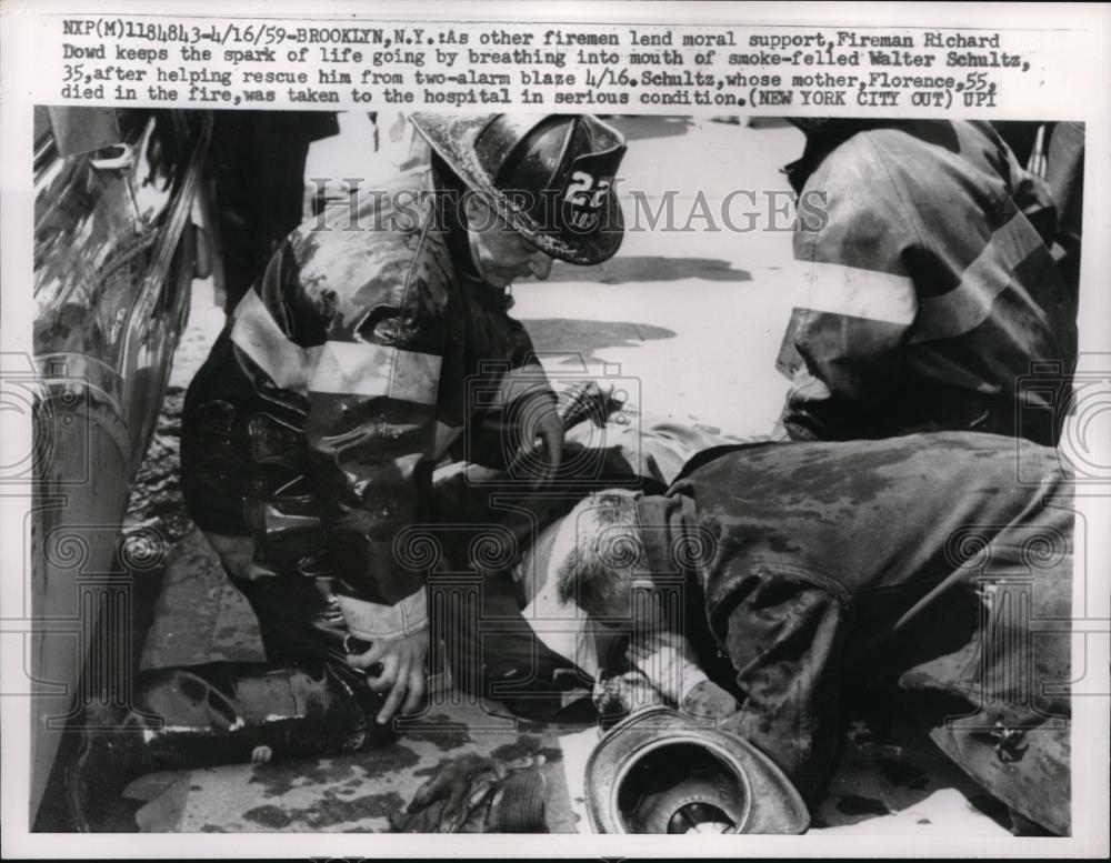 1959 Press Photo Fireman Richard Dowd tries to save Walter Schultz, 35 - Historic Images