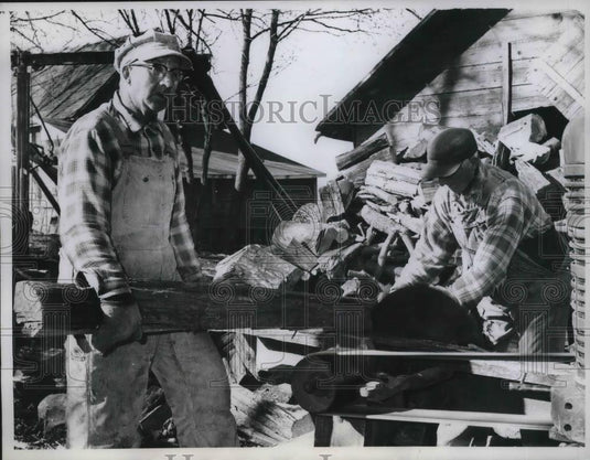 1961 Press Photo The Helle Brothers stocking up a huge pile of wood - Historic Images