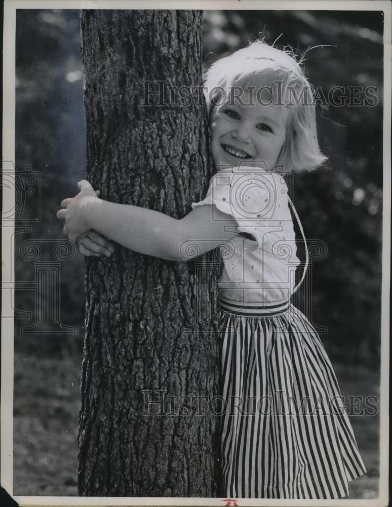 1961 Press Photo Julie Arms, 4, wrapping her arms around a tree - Historic Images