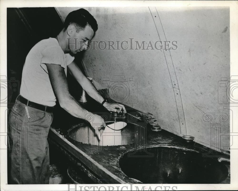 1945 Press Photo Coast Guardsman Gilbert wallen &amp; plumbing sink with drums - Historic Images