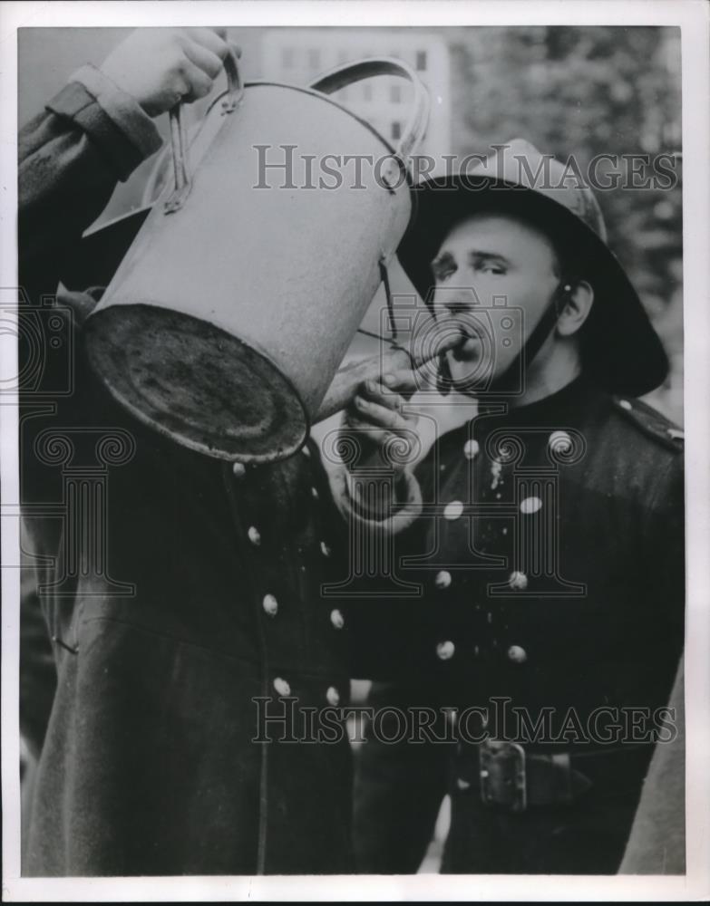 1954 Press Photo A London Fire Fighter Takes A Self Conscious Gulp From Water - Historic Images