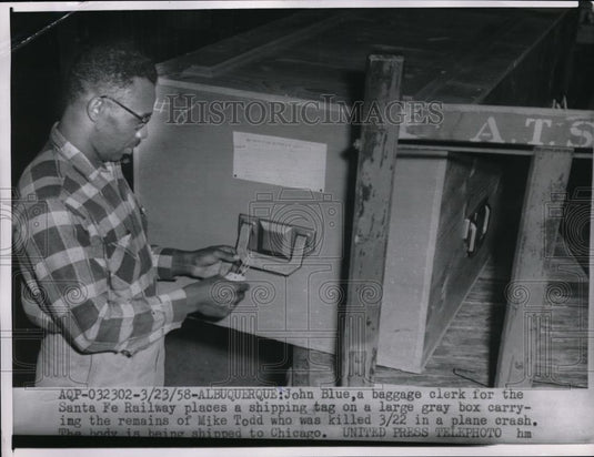 1958 Press Photo Baggage Clerk John Blue Puts Shipping Tag On Large Gray Box - Historic Images