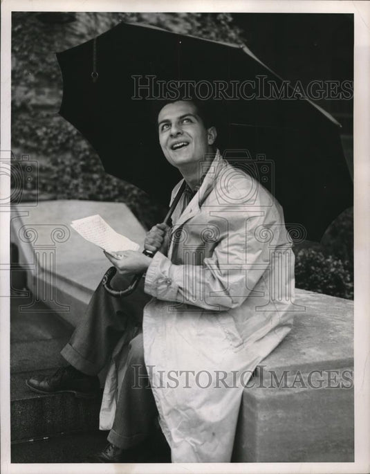 1956 Press Photo Elias Ahood admiring his surrounding in an umbrella during a - Historic Images