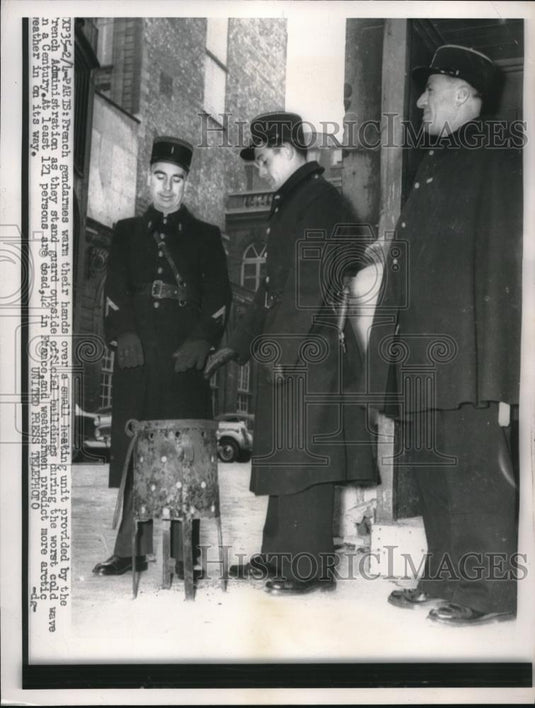 1956 Press Photo French Gendarmes try to get warm while guarding bldg. in Paris - Historic Images
