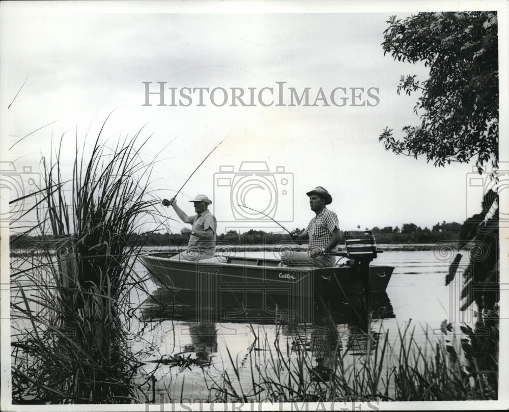 Press Photo Two men fishing in small motor boat - Historic Images