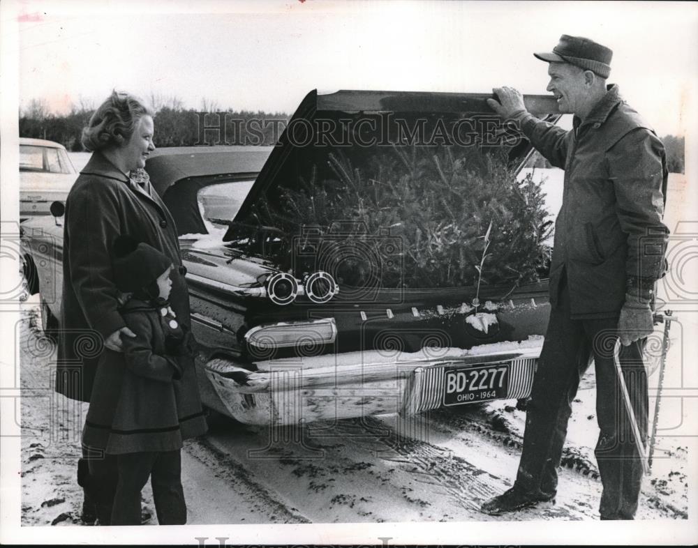 1964 Press Photo Mother &amp; Child Getting Christmas Tree Put In Trunk By Worker - Historic Images