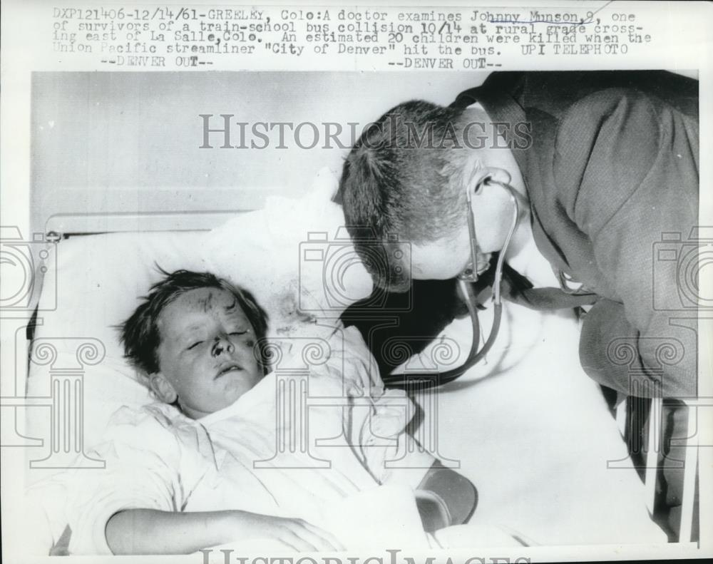 1961 Press Photo Greeley, Colo doctoe examines J Munson, 9 after bus crash - Historic Images